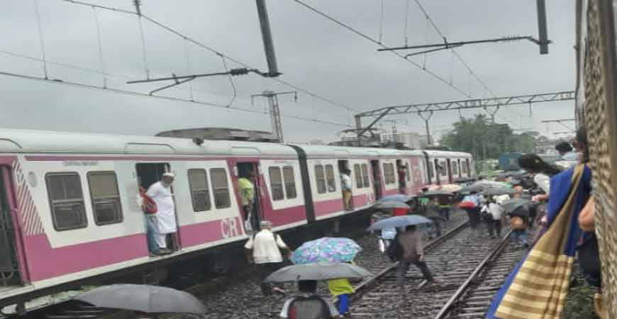 मुंबई में भारी बारिश से ट्रेनें रुकीं, यात्री स्टेशन पर फंसे