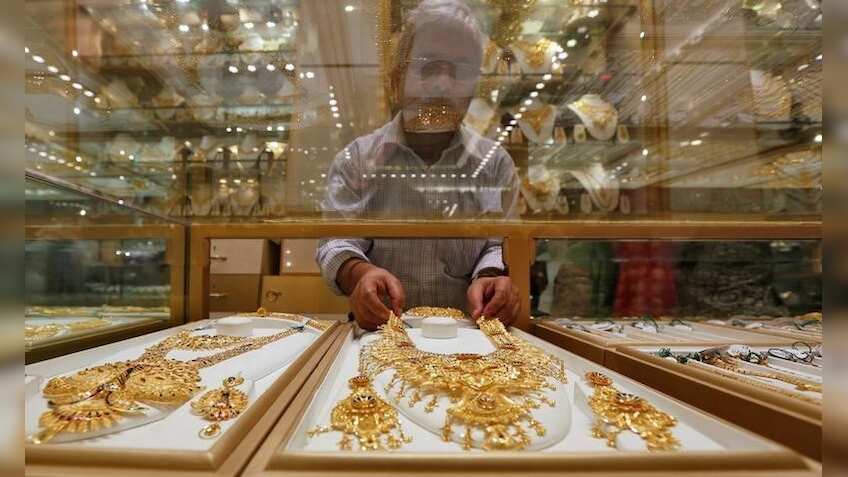 Gold holds gains on weaker dollar, rising stocks cap gains