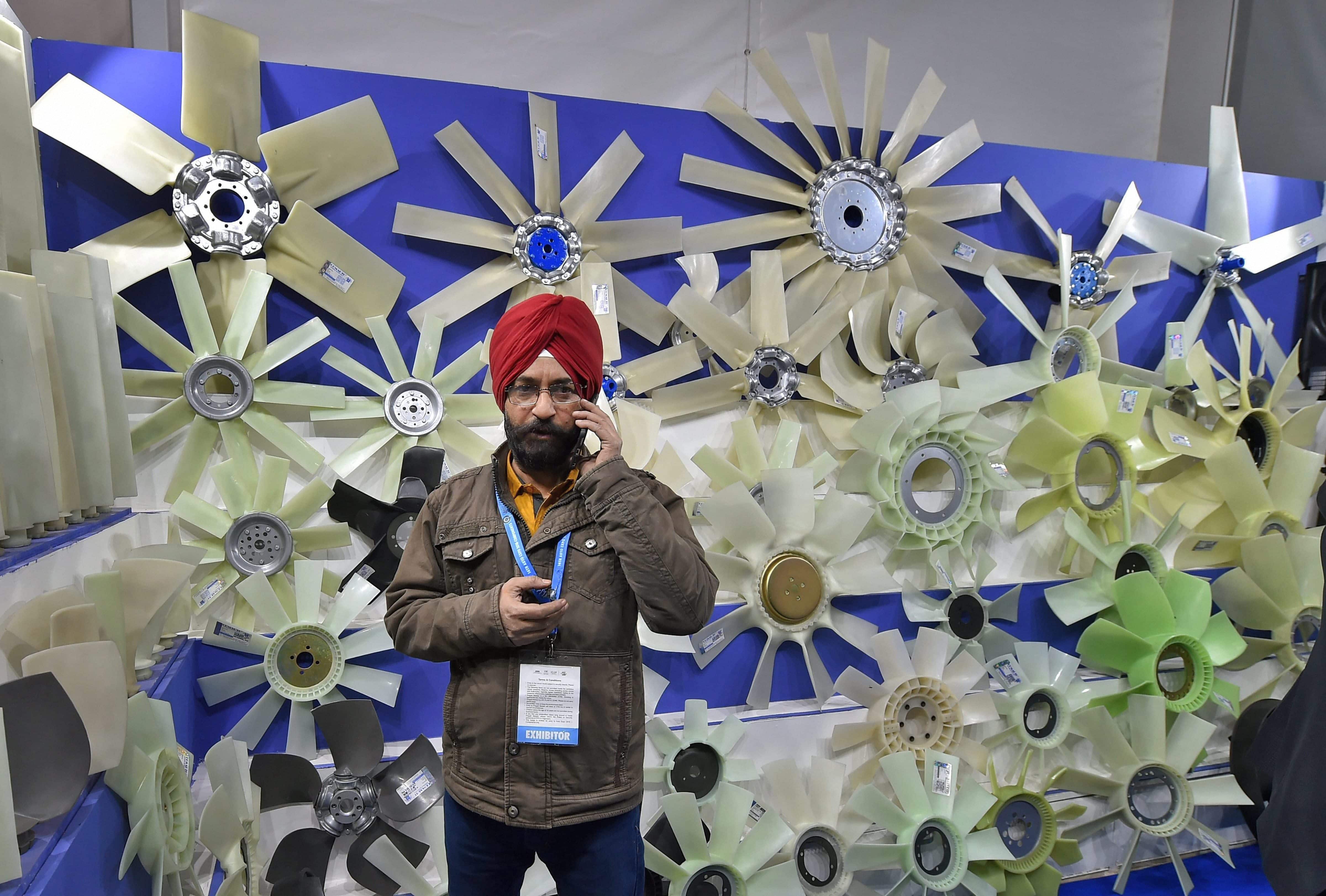 An exhibitor stands at a stall at the Auto Expo Component 2018 that began at Pragati Maidan in New Delhi on Thursday. PTI