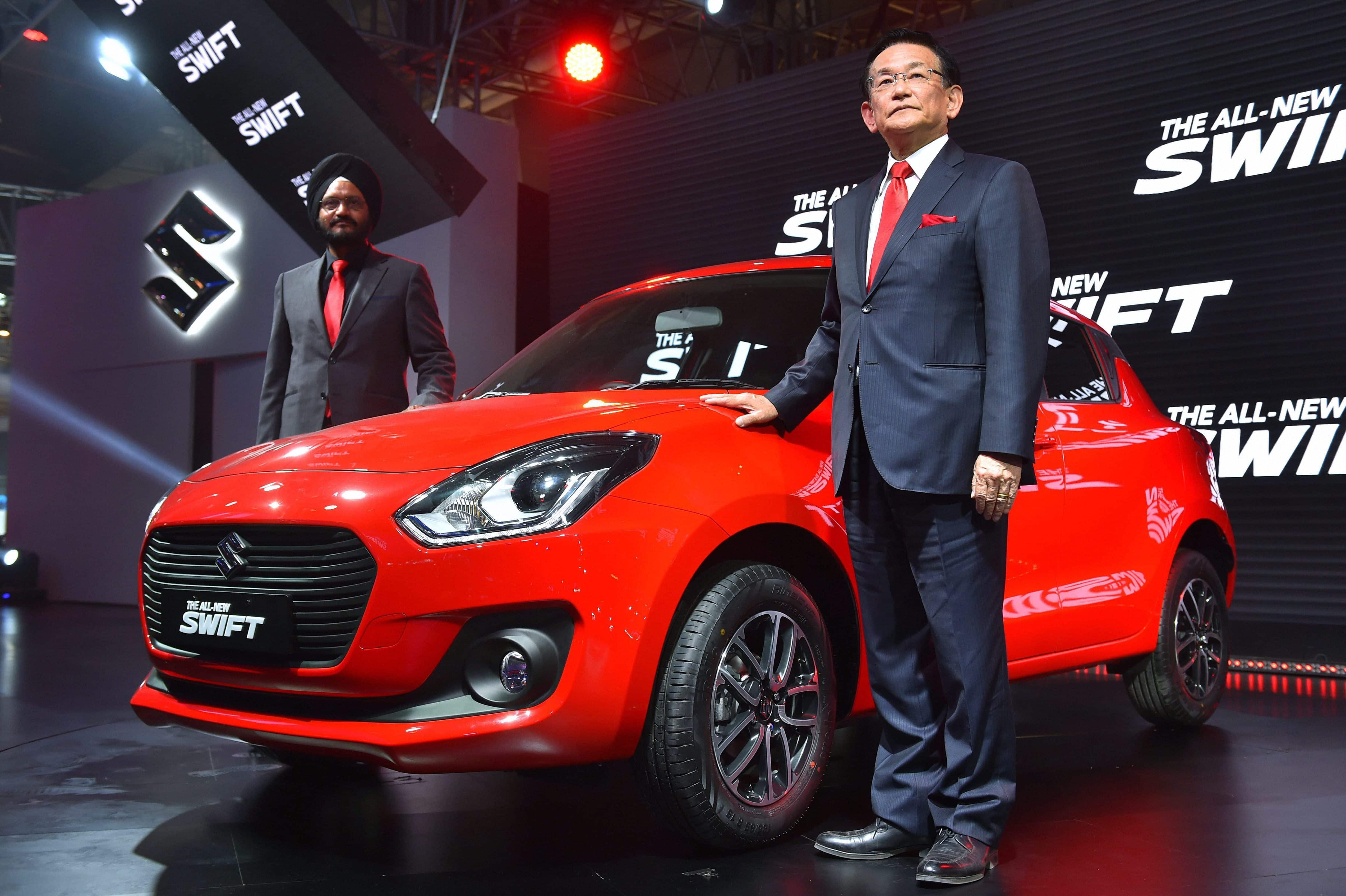 Maruti Suzuki's Managing Director & CEO Kenichi Ayukawa (R) and Senior Executive Director, Marketing and Sales, RS Kalsi showcase the company''s all-new Swift at the Auto Expo 2018 in Greater Noida.  PTI 