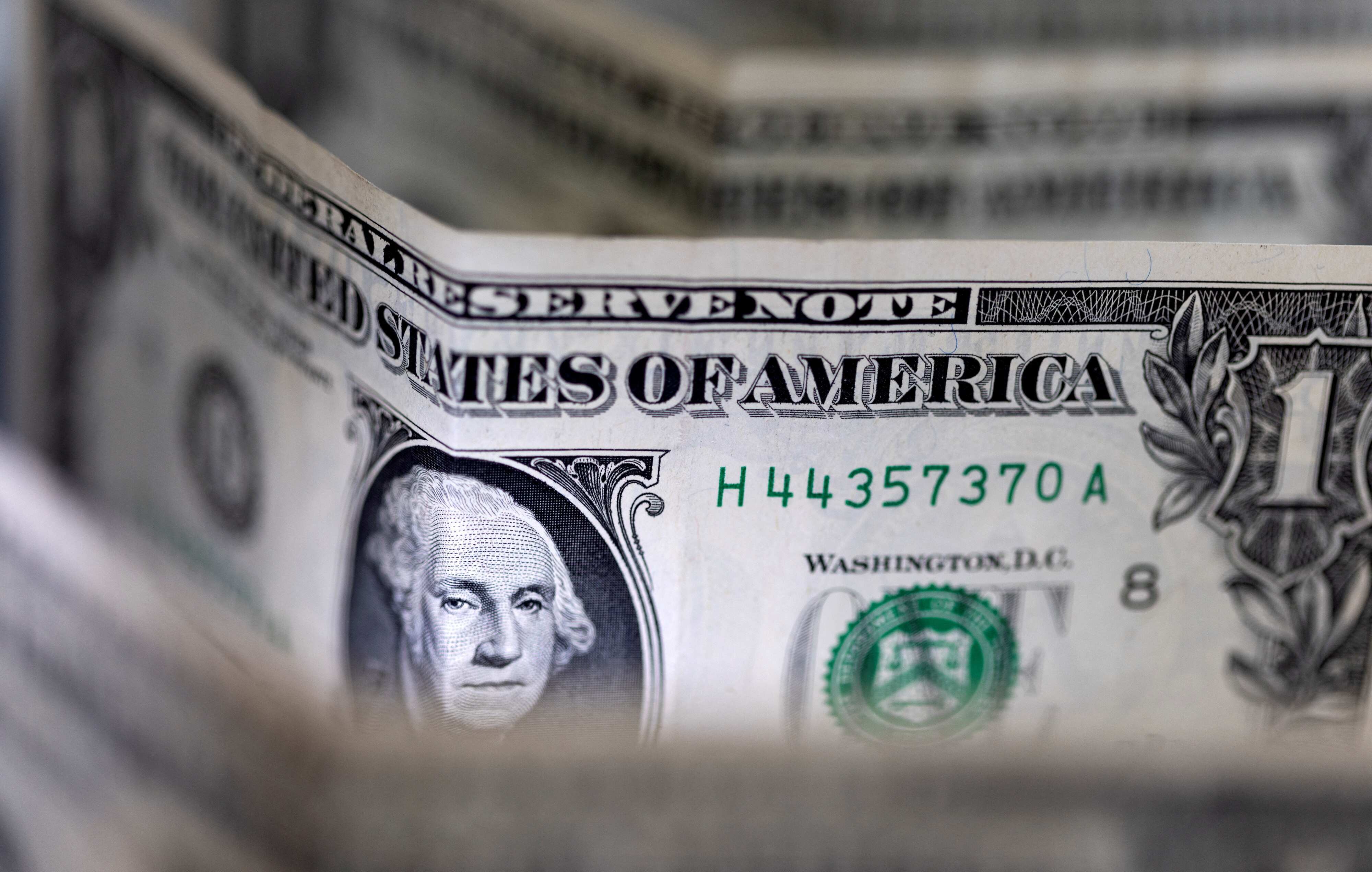 Dollar edges lower but poised for weekly gain as early rate cut hopes dim