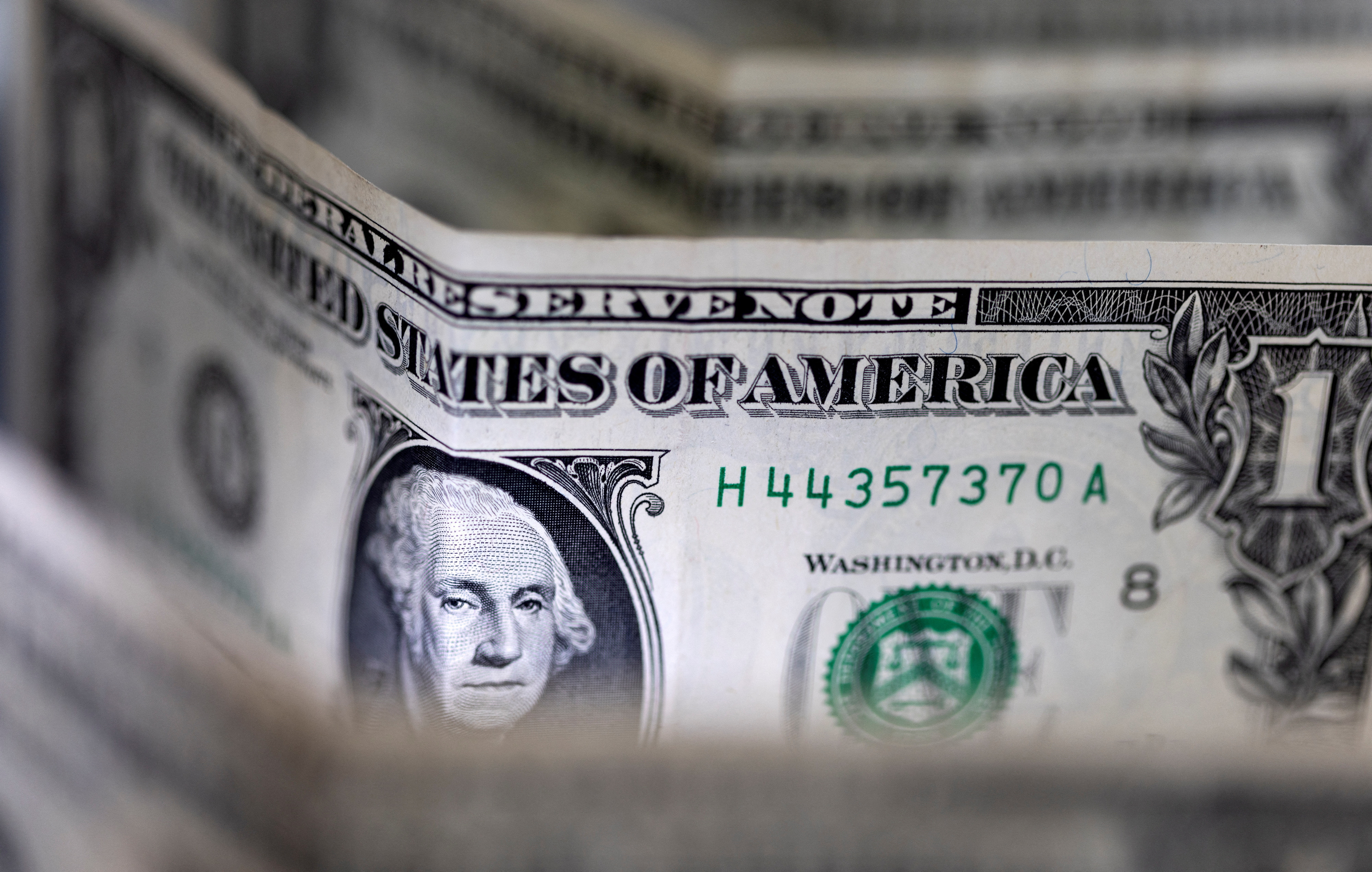 Dollar edges lower but poised for weekly gain as early rate cut hopes dim