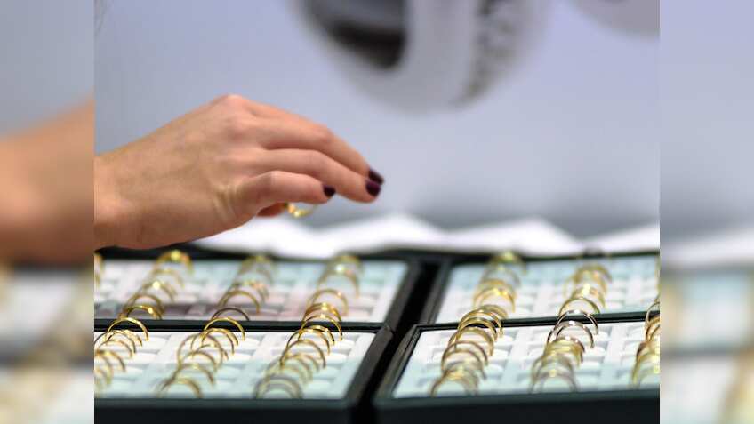 Gold hovers near record high as market focus turns to US data, Fed minutes