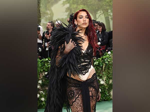 Dua Lipa poses in a black lace gown