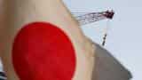 Bank of Japan keeps policy on hold, brightens view of economy