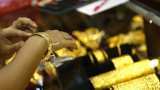 Gold edges down as Federal Reserve interest rate view strengthens dollar