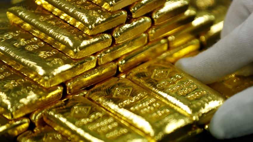 Gold up on weaker dollar, heads for fifth gain on week