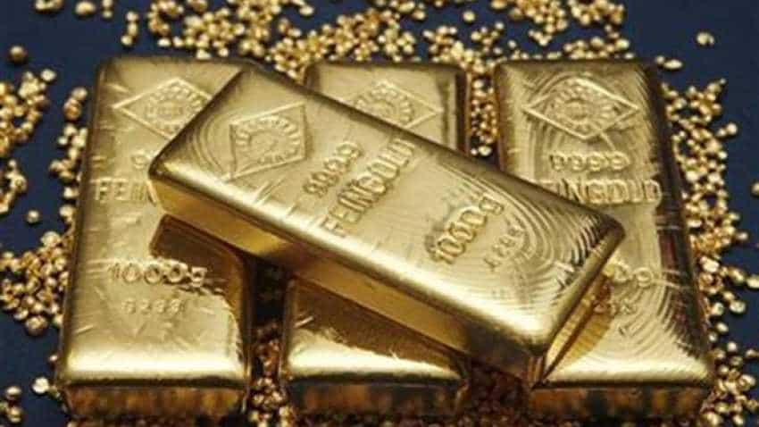 Gold inches down as trade worries boost dollar