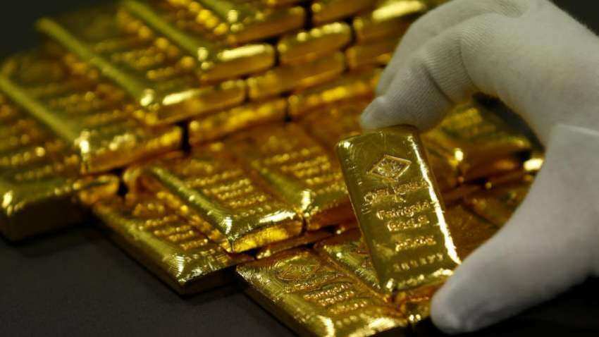 Gold hits over one-week high as dollar, yields slip